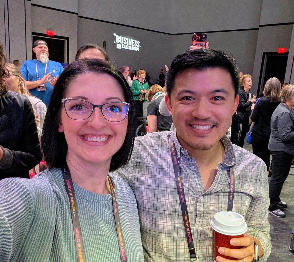 Aaron and Heidi at a business event, a room of owners behind them